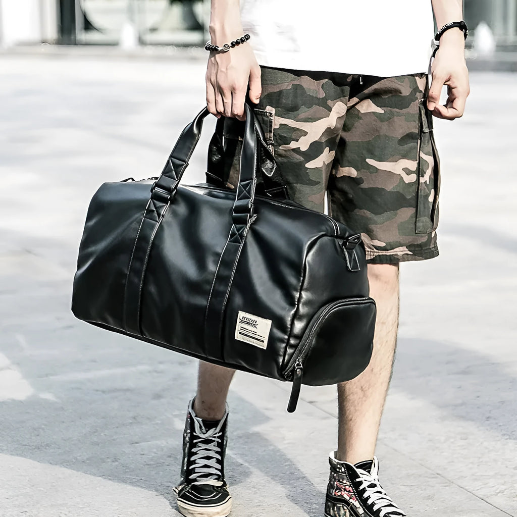 Black PU leather sports training bag showing internal organiser pockets for laptop and phone.