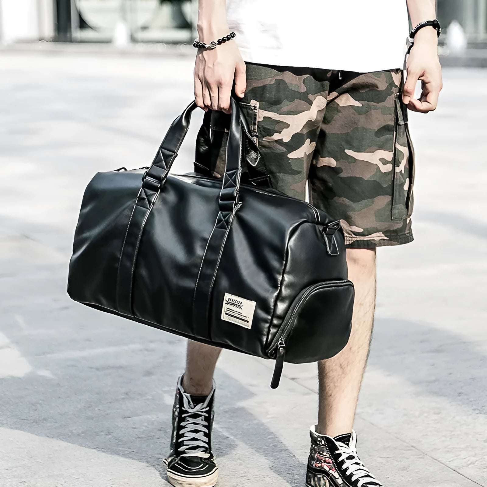 Black PU leather sports training bag showing internal organiser pockets for laptop and phone.