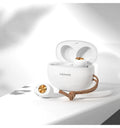 Wireless black TWS earbuds next to their small white charging case on a table.