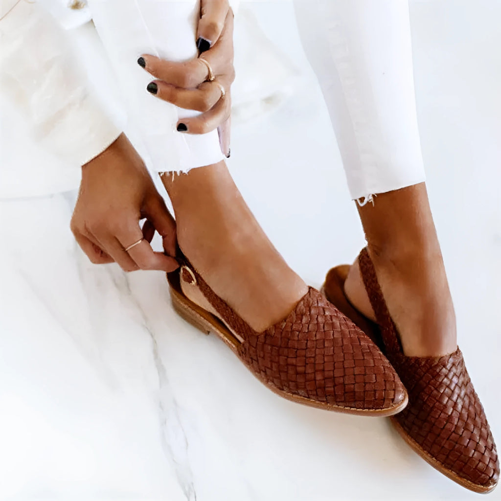 Women's black flat sandals with a pointed toe and metal buckle closure on a microfiber upper.