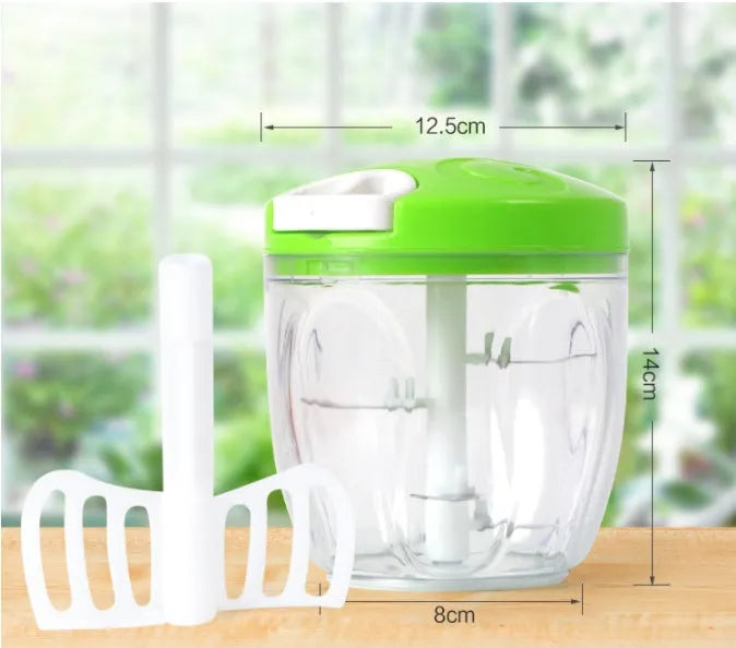 Green manual kitchen chopper with lid, showing stainless steel blades inside, on a countertop.