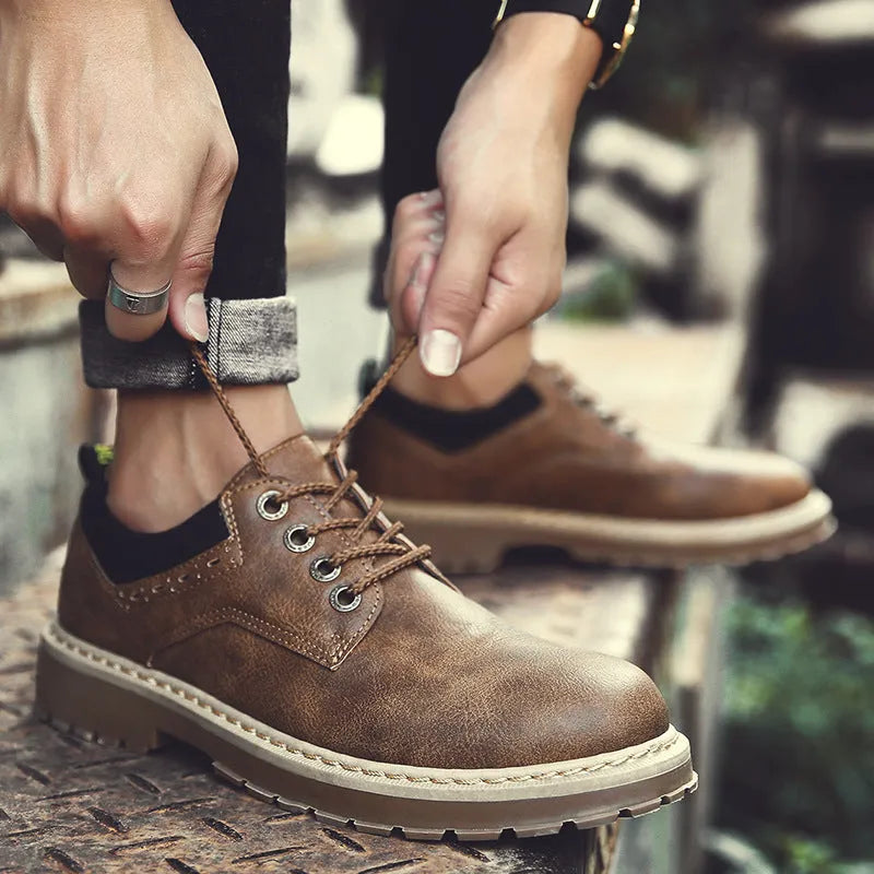 Men's black casual shoes with round toe, flat heel, and front-tie laces on a rubber sole.