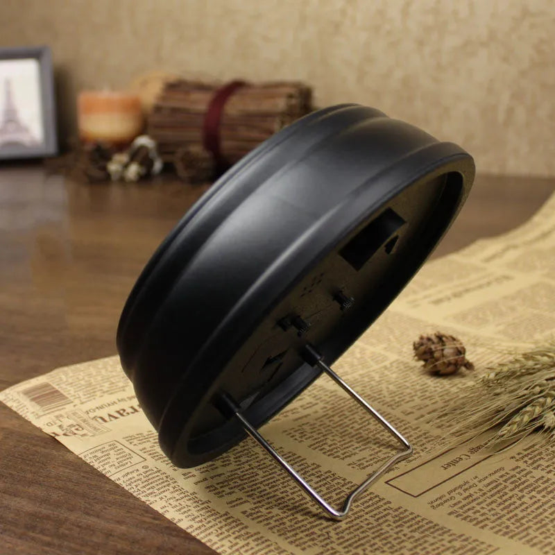 Round European style retro desk clock with silent alarm on a wooden surface.