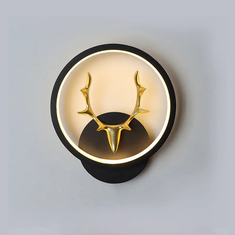 Deer antler shaped wall lamp with remote control on a light-coloured wall.
