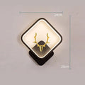 Deer antler shaped wall lamp with remote control on a light-coloured wall.