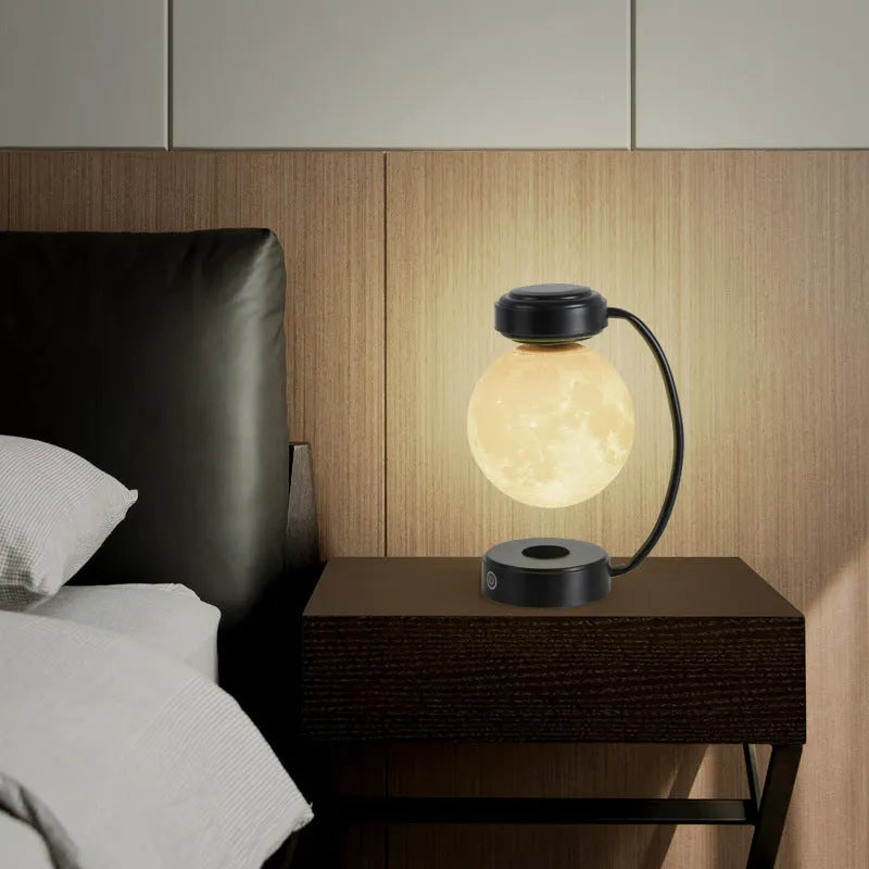 Black and gold magnetic levitation moon lamp with three-colour light changing on bedside table