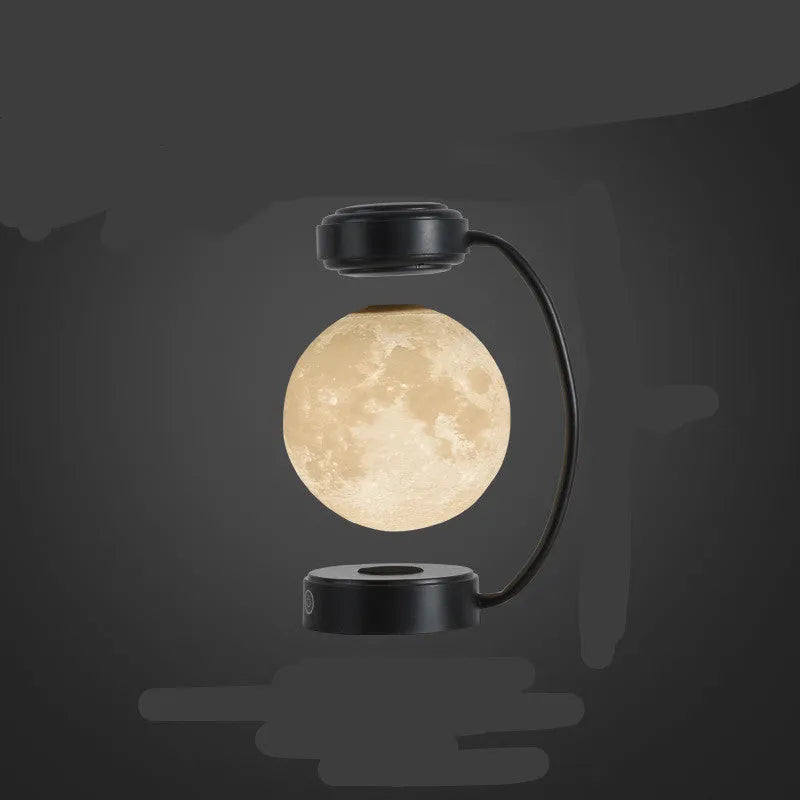 Black and gold magnetic levitation moon lamp with three-colour light changing on bedside table