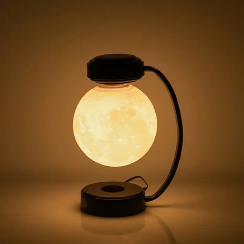 Black and gold magnetic levitation moon lamp with three-colour light changing on bedside table
