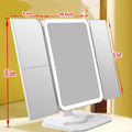 Trifold LED makeup mirror with 68 lights, 10X detachable magnifier, silver surface, rotating 180 degrees on a tabletop