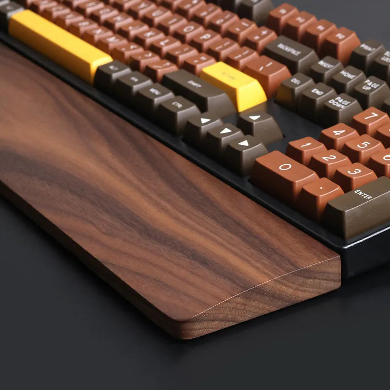 Solid walnut wood keyboard wrist rest for ergonomic forearm support.