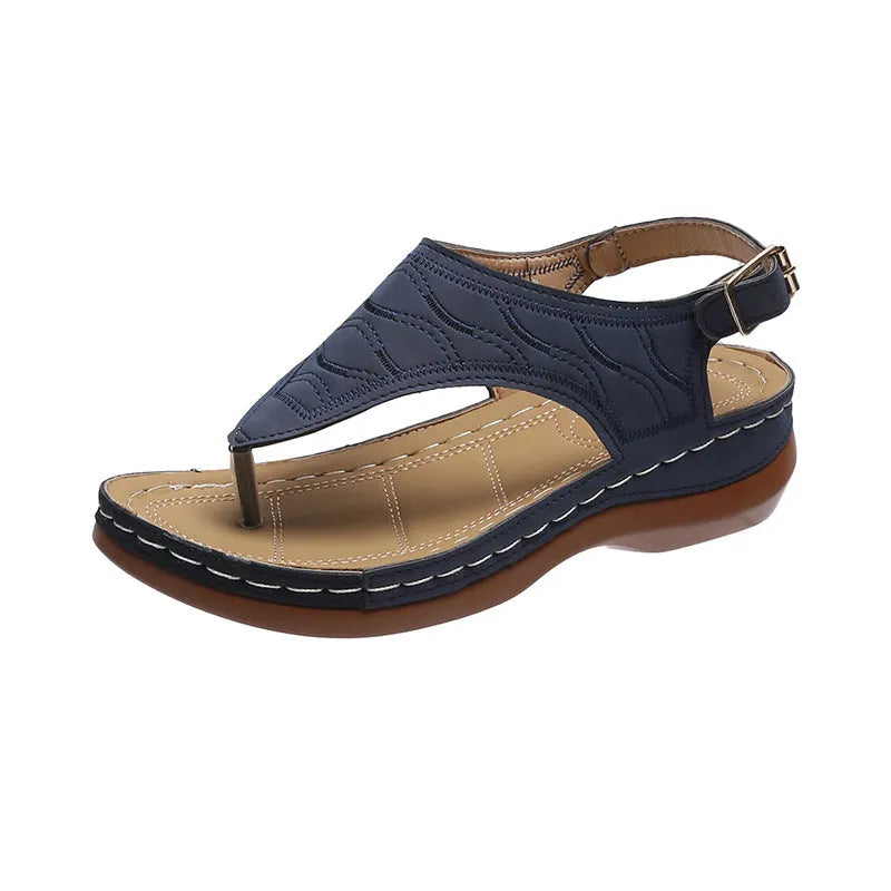 Women's red wedge heel sandals with an adjustable buckle strap on a plain background.