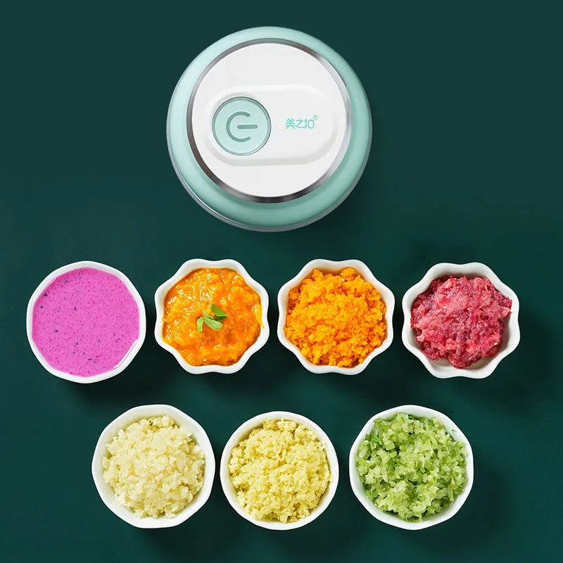 Mini electric food chopper with transparent cup and stainless steel blade on a kitchen counter.