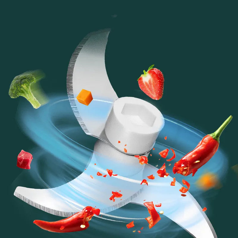 Mini electric food chopper with transparent cup and stainless steel blade on a kitchen counter.