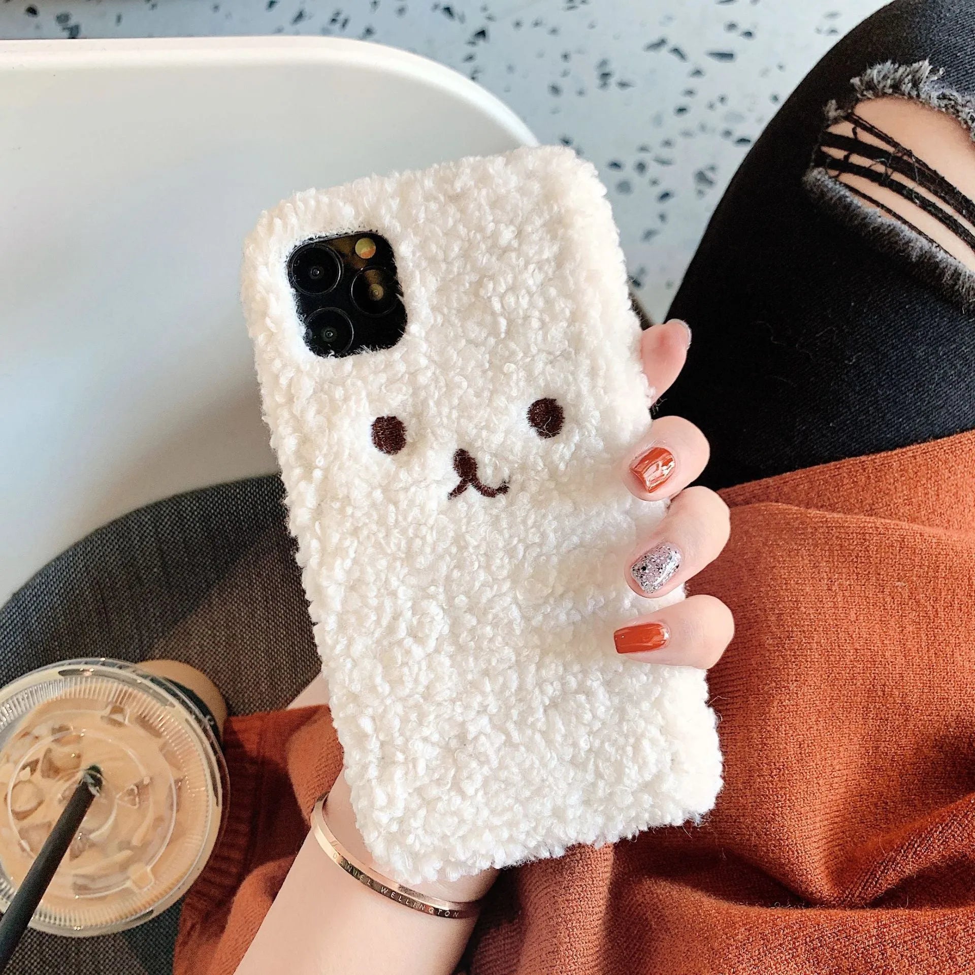 Brown embroidered plush bear face on a soft TPU iPhone phone case.