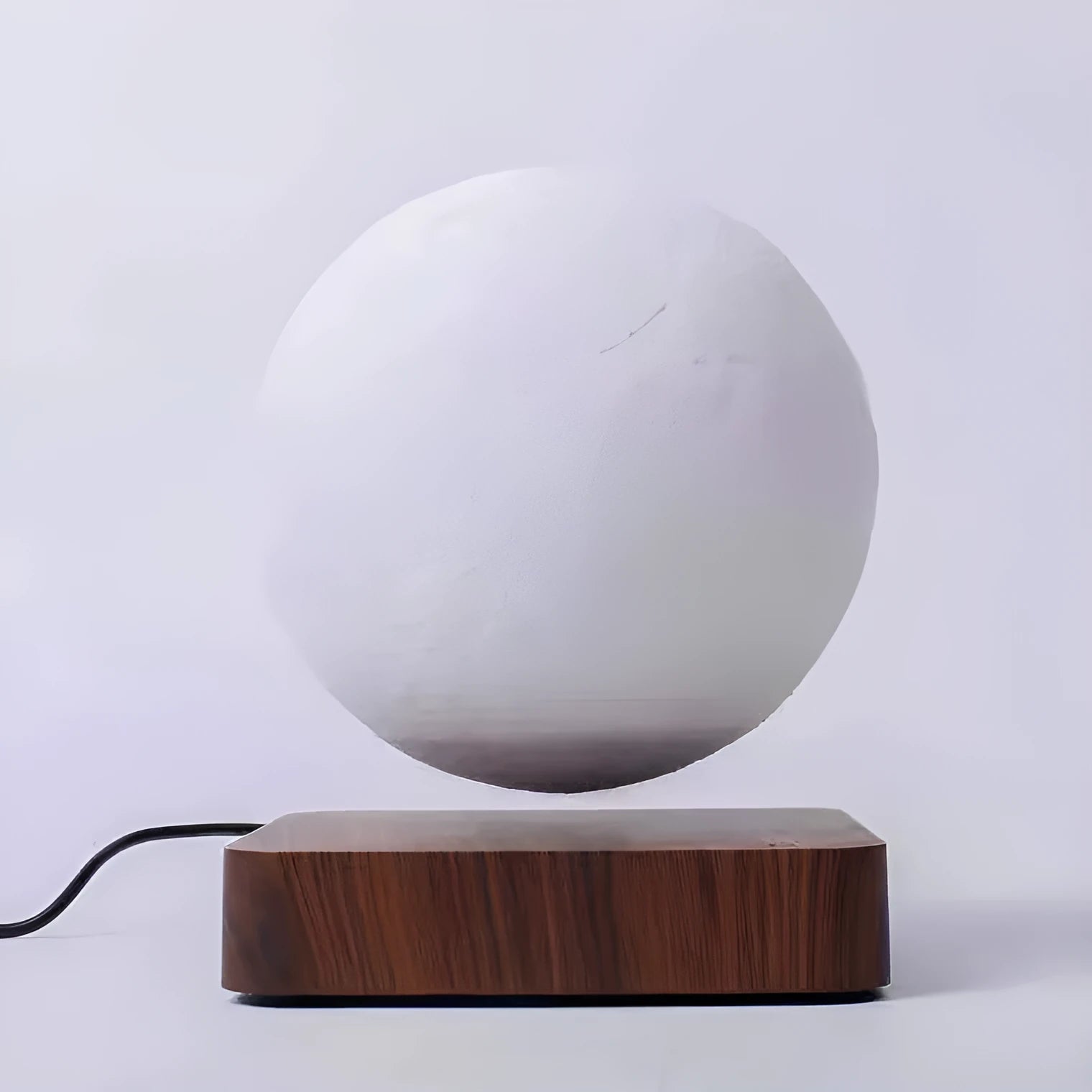 Magnetic levitation moon night light with 14cm 3D-printed planet suspended above a dark peach wood base
