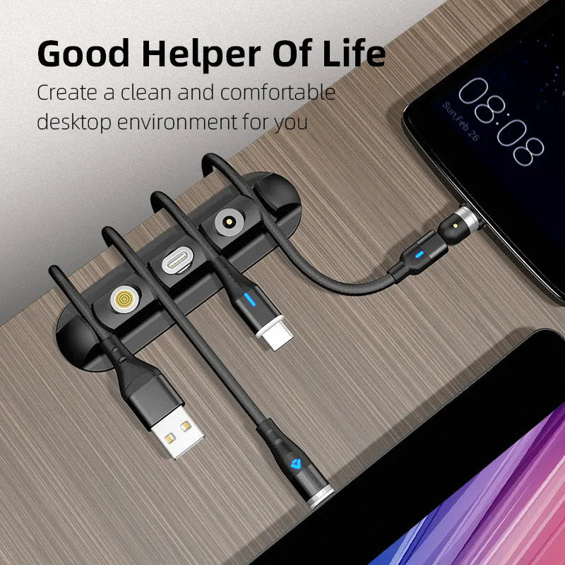 Black soft plastic desktop organiser holding magnetic charging cables on a wooden desk.