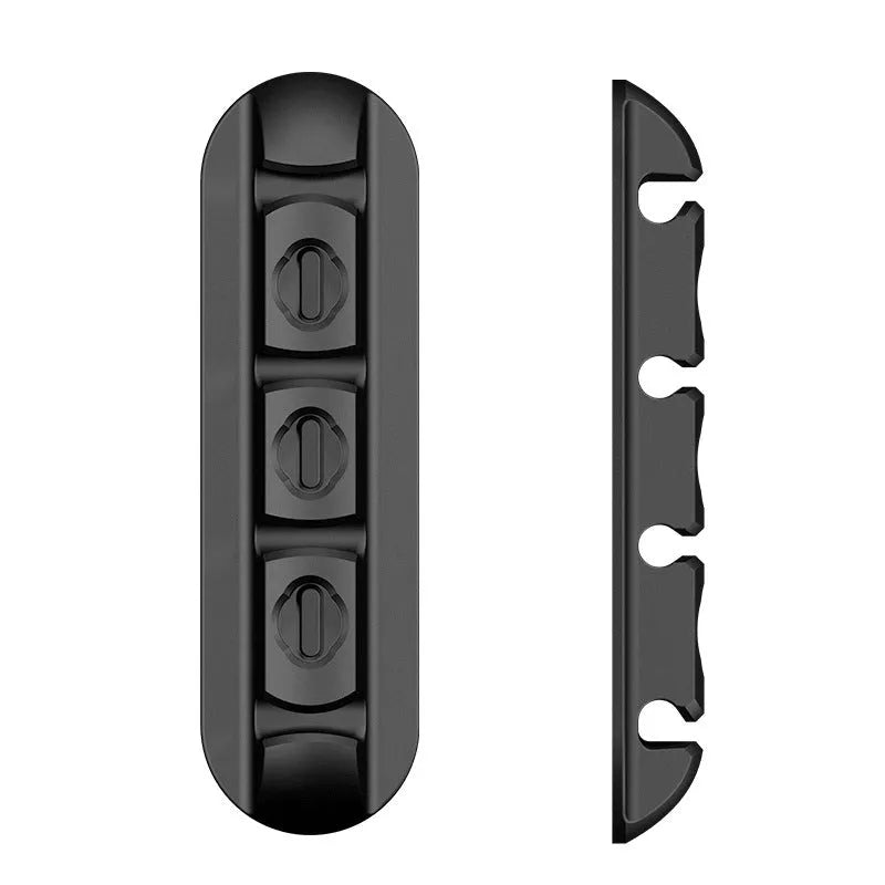 Black soft plastic desktop organiser holding magnetic charging cables on a wooden desk.