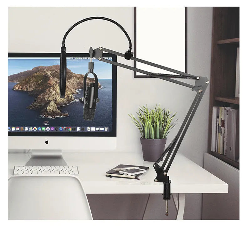 Black USB condenser microphone on a metal desk stand with a foam windscreen attached.