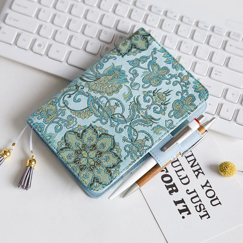 Blue floral fabric notebook open showing pages, available in A5 and A6 sizes.