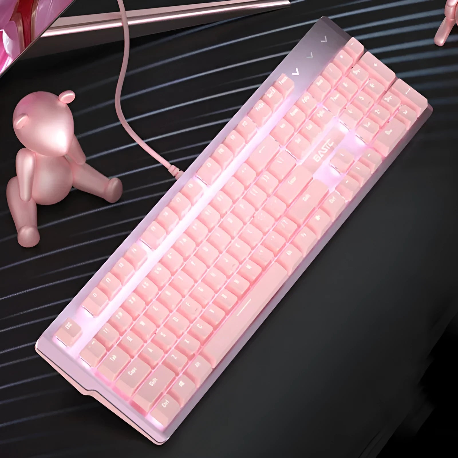 Pink wired mechanical keyboard and matching mouse set on a desk.