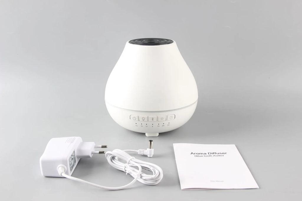 White round Bluetooth humidifier and aroma diffuser with night light on a surface.