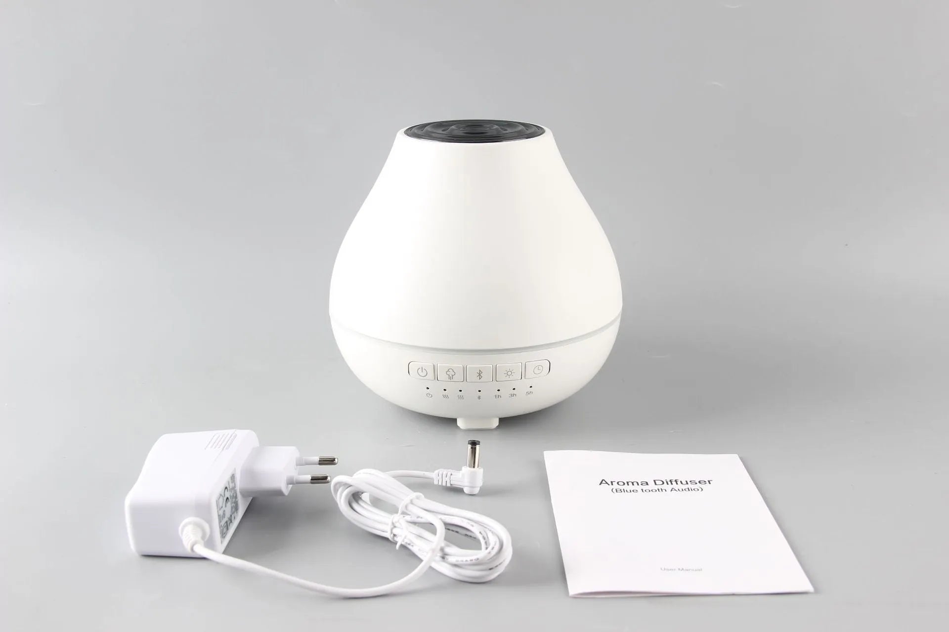 White round Bluetooth humidifier and aroma diffuser with night light on a surface.