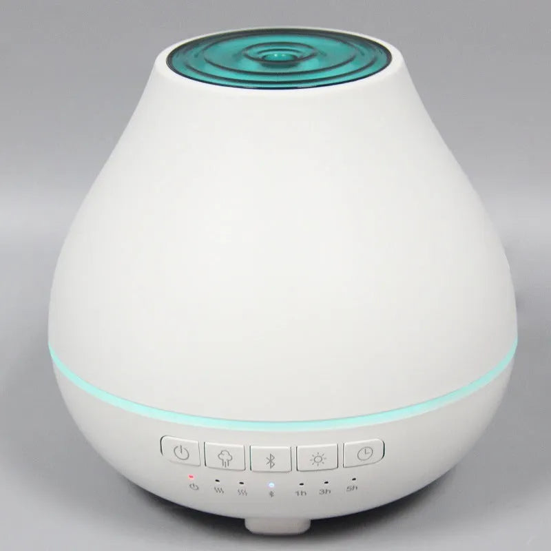 White round Bluetooth humidifier and aroma diffuser with night light on a surface.