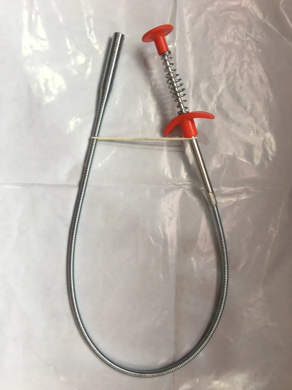Black sewer dredger spring drain cleaning tool with handle and coiled end for pipe unclogging.