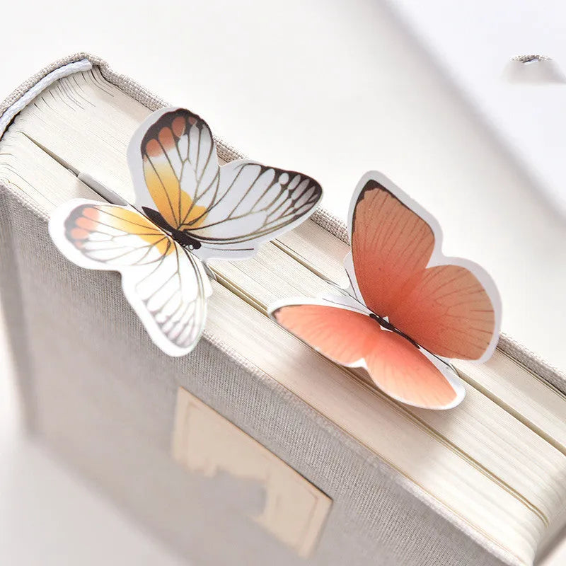 A single butterfly-shaped paper bookmark on a white background, showing its flat design and approximate 13.5cm by 5.5cm size.