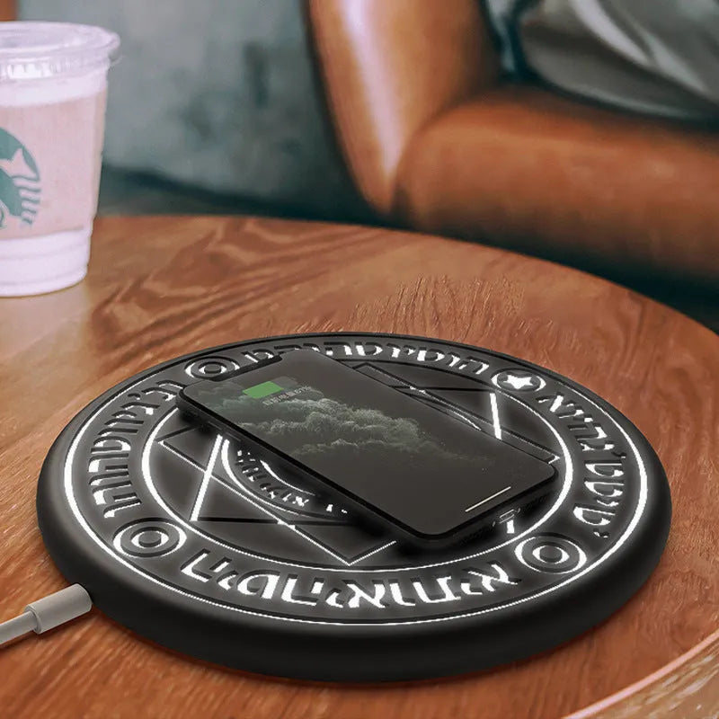 Square 25cm 10W fast wireless phone charger with glowing magic array pattern in black on a desk