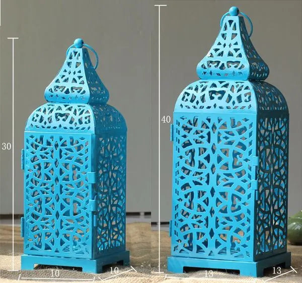 Blue iron geometric Moroccan candelabro candle holder on a wooden table.