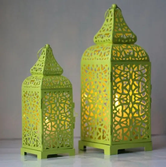 Blue iron geometric Moroccan candelabro candle holder on a wooden table.