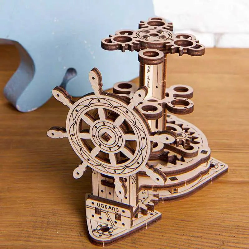 Wooden steering wheel model that rotates and functions as a pen holder on a desk.