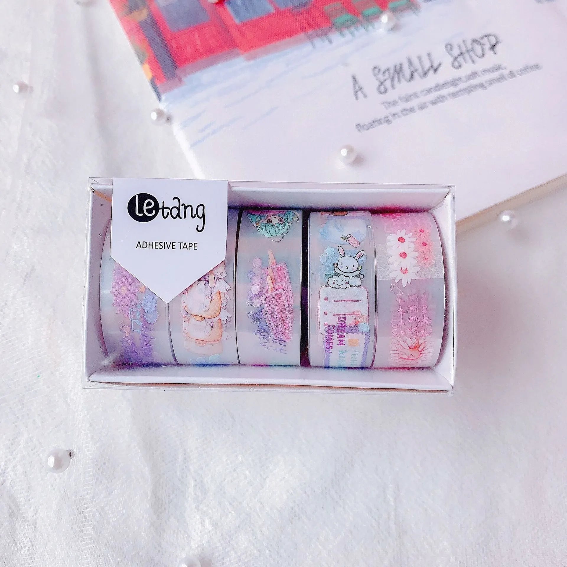 Five rolls of colourful washi paper sticker tape with cartoon designs of dinosaurs, ducks, cats, girls, and rabbits.