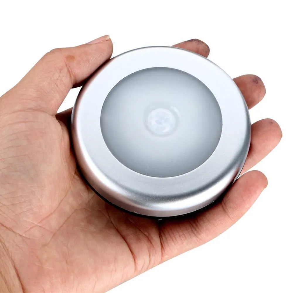 Silver wireless motion sensor night light showing compact 80mm design with LED illumination