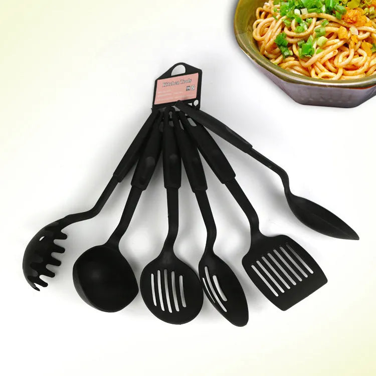 Black rubber and silicone kitchen utensil set with a solid spoon, slotted spoon, and spatula for non-stick pans.