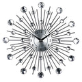 Large round silver mute wall clock with metal frame and numbered dial on a wall.