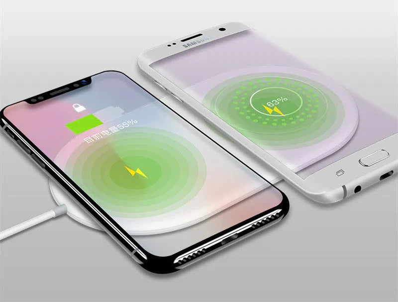 White dual wireless phone charger charging two mobile phones simultaneously on tabletop