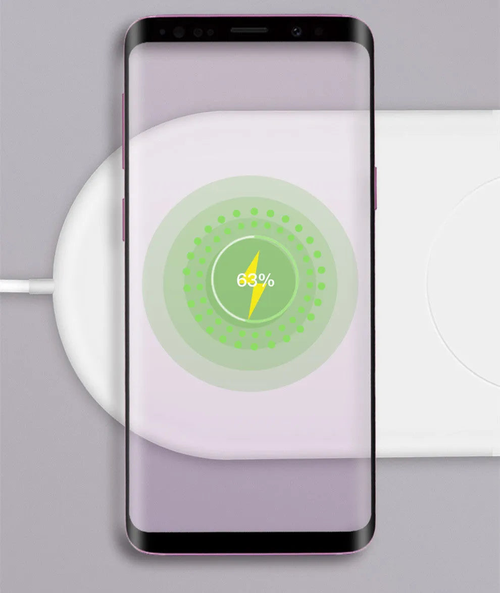 White dual wireless phone charger charging two mobile phones simultaneously on tabletop
