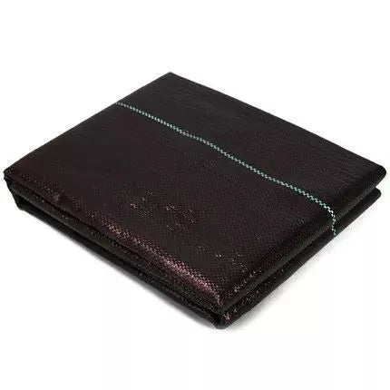 Black polyethylene weed-proof ground cover cloth laid flat on soil, showing woven texture.