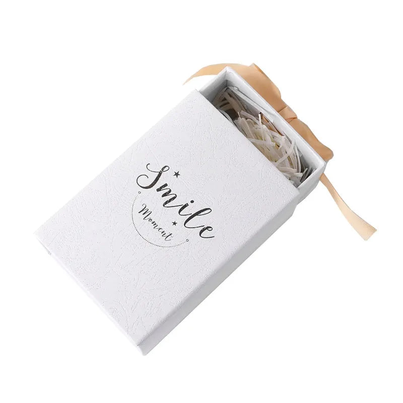 Small cardboard gift box set with matching handbag and raffia detail in blue, pink, red, or white.