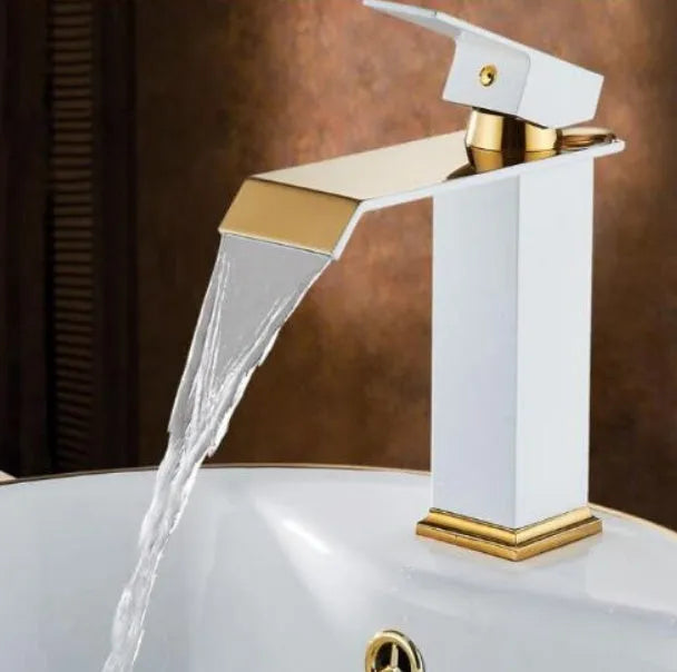 Black and white brass basin faucet with gold accents and waterfall water flow design