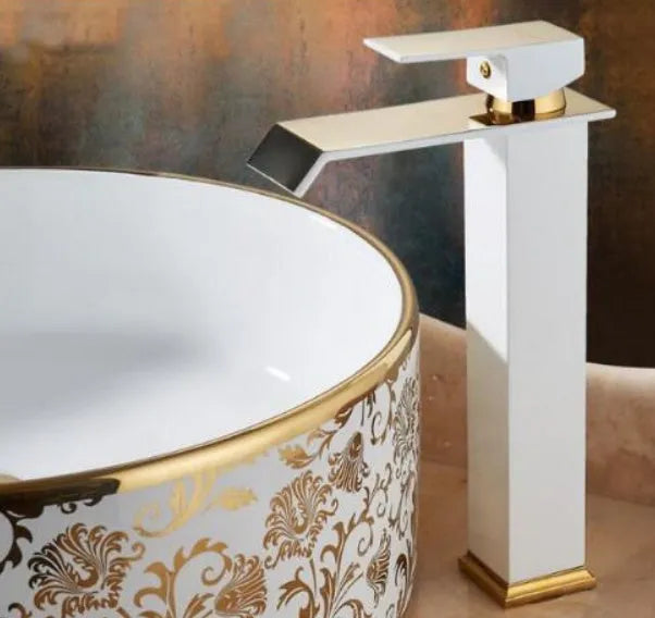 Black and white brass basin faucet with gold accents and waterfall water flow design
