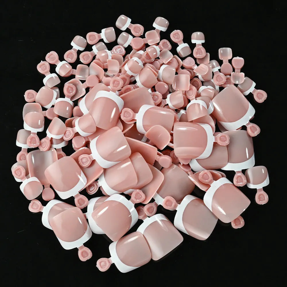 120 piece set of nude French white tip artificial toenails in nine shades, showing square short shape.