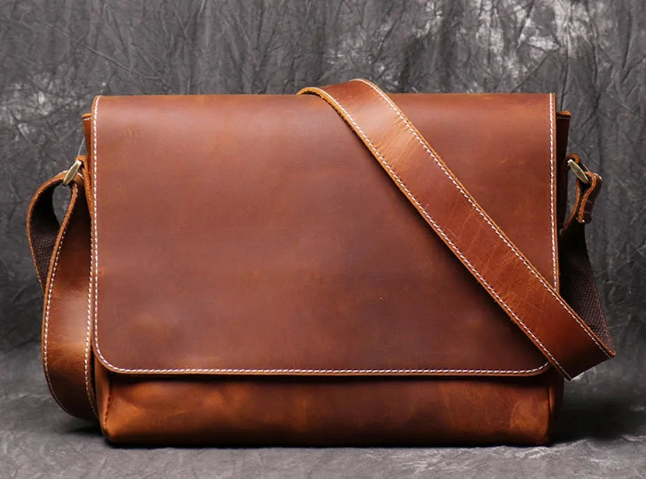Men's vintage brown cowhide shoulder bag showing medium size and cross-body strap