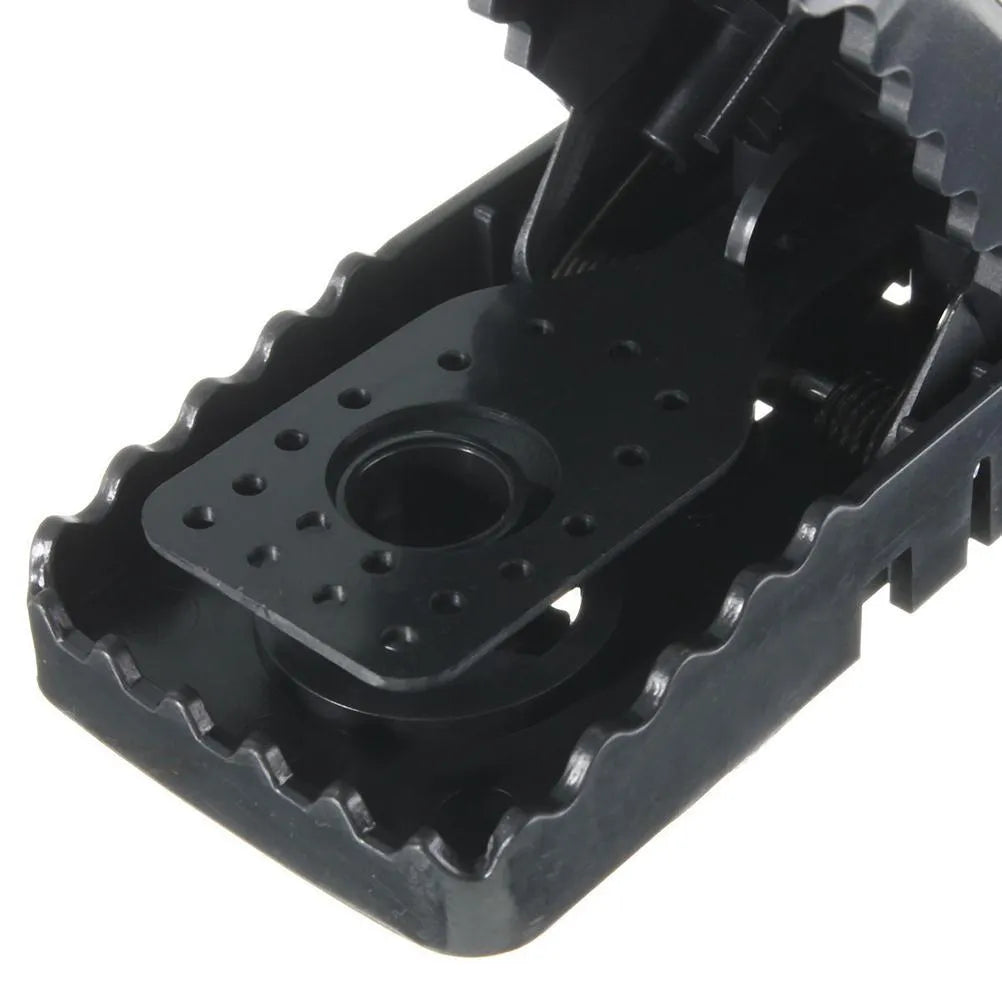 Set of six black plastic snapping mousetraps showing size and smooth surface