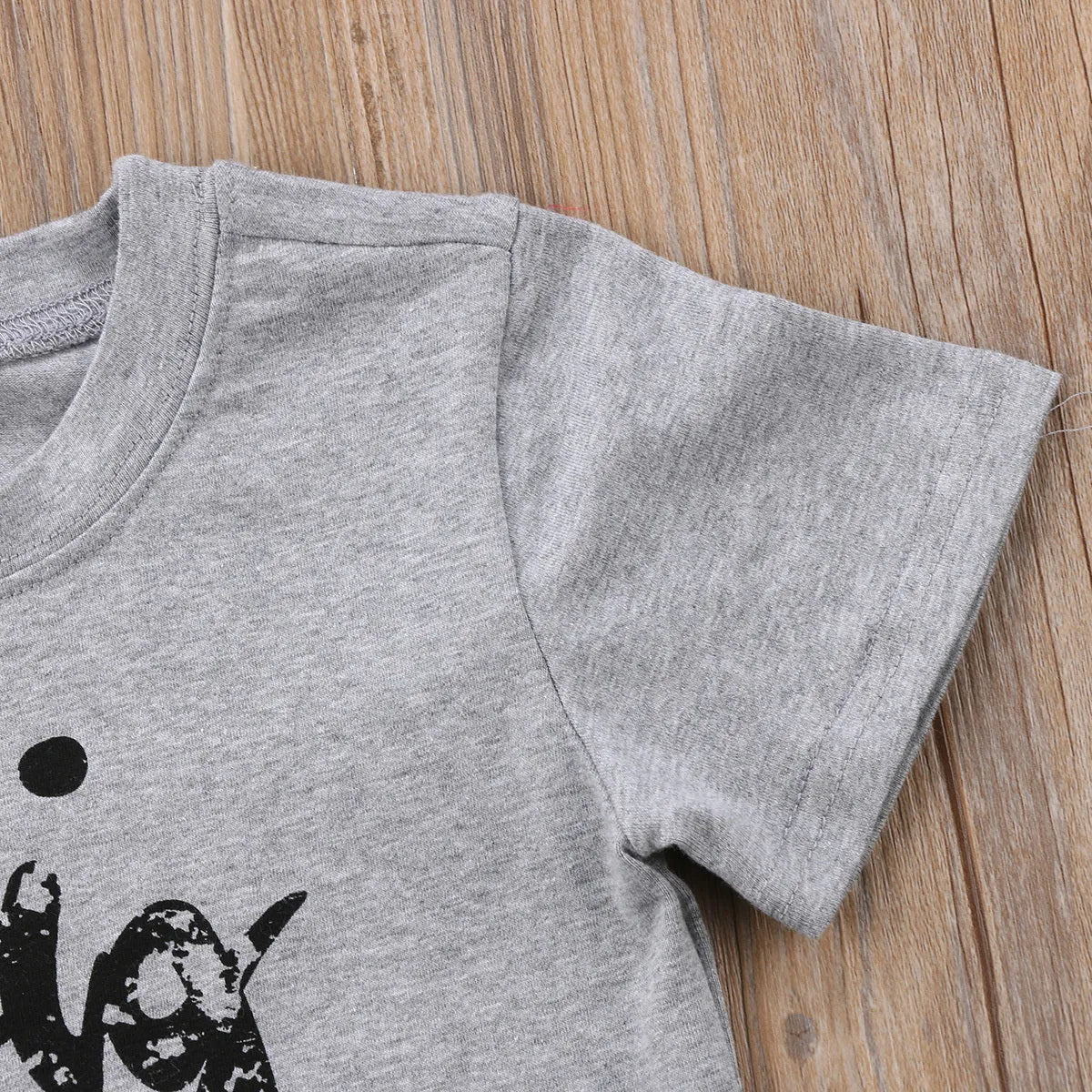 Grey cotton children's t-shirt with printed sibling graphic, showing size range from 60cm to 140cm.