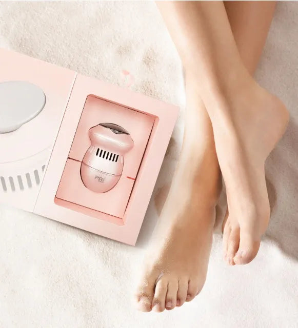 Beige and white electric foot file machine with grinding head, USB cable, two spare heads, brush, and sponge ring.