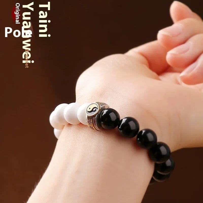 Black and white Taiji symbol bracelet made from obsidian beads with engraved mantra.