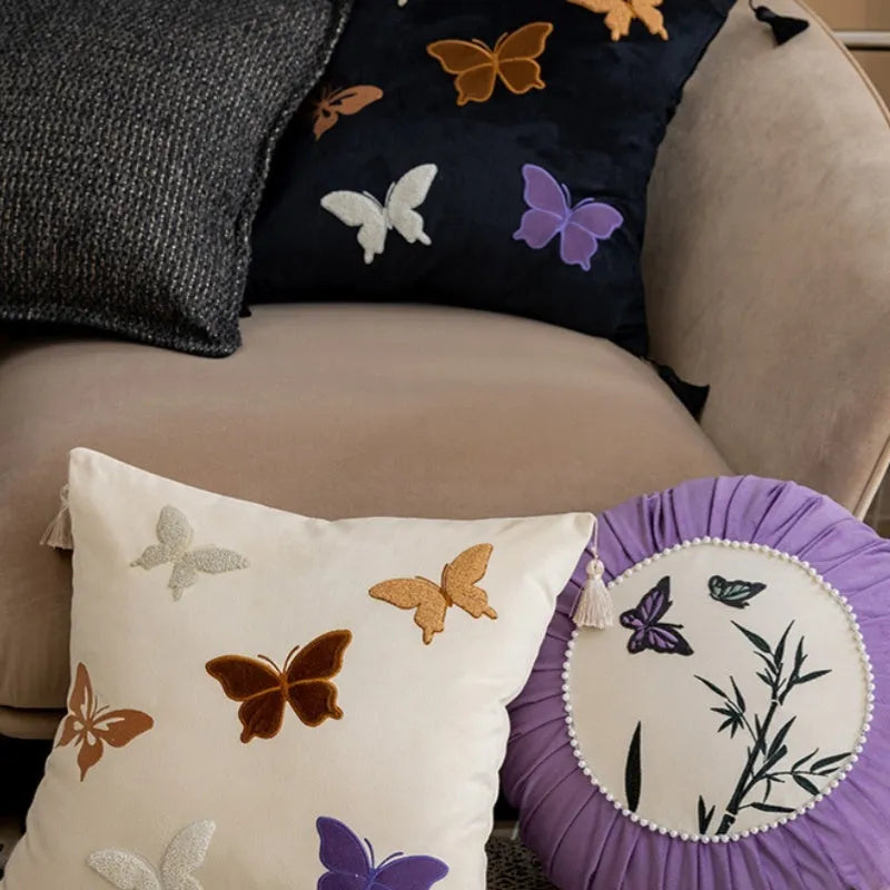 Square beige cushion with detailed black butterfly embroidery in a Chinese style.